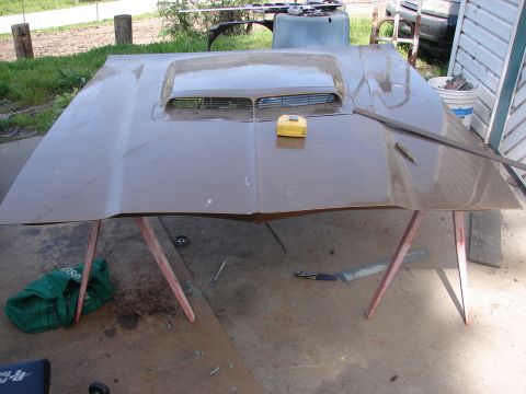 1973 Ford Ranchero - A car hood with a large air intake scoop is displayed outdoors, supported by sawhorses.