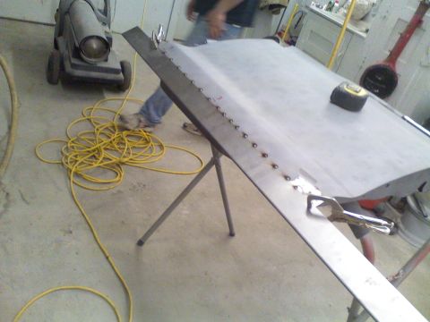 1979 Ford F-250 - A car door panel is being worked on in a garage setting, with tools and equipment visible.