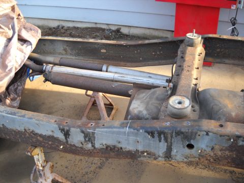 1954 Ford F-100 - Truck chassis components, including frame rails and exhaust system, are supported by jack stands.