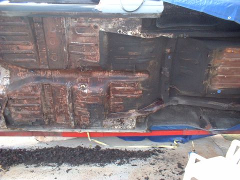 1964 Ford Fairlane - The undercarriage of a vehicle is visible, showing signs of rust and wear.