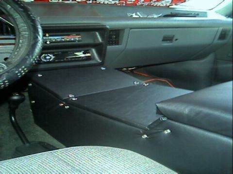 1989 Ford Bronco - Interior shot of a custom-built center console fabricated in black vinyl with visible screw heads, spanning from the dash to between the se…