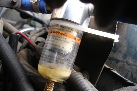 1995 Ford Taurus - Close-up of an engine part, possibly a filter or separator, with a prominent warning label.