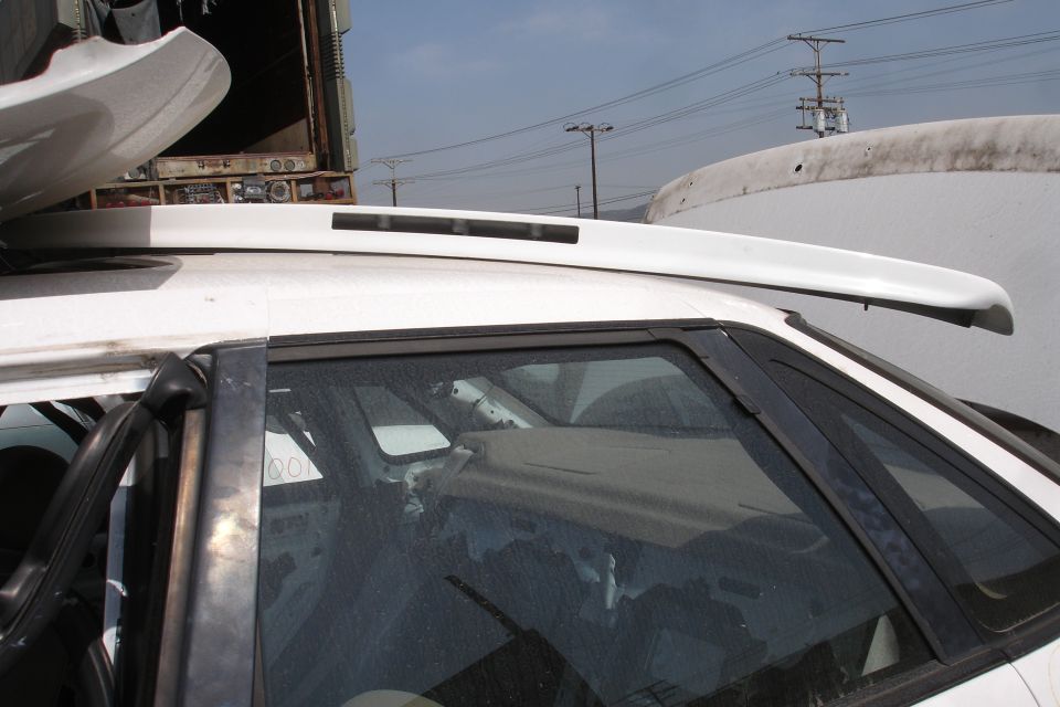 White car roof spoiler mounted above rear window, with interior visible through glass