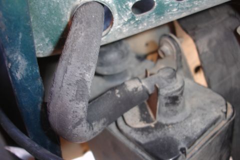 1995 Ford Taurus - Close-up view of a rubber engine hose connected to a black plastic reservoir or component.