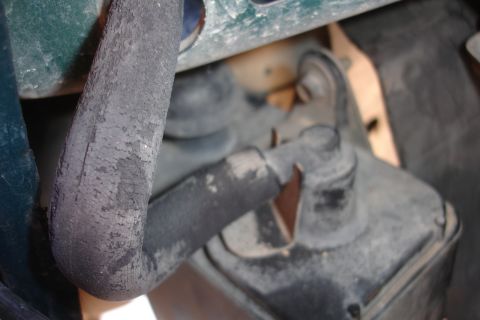 1995 Ford Taurus - Close-up of a worn rubber hose and associated engine component, possibly a vacuum line or fluid reservoir.