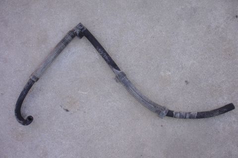 1995 Ford Taurus - A worn automotive hose, likely a coolant or vacuum line, is shown against a concrete background.