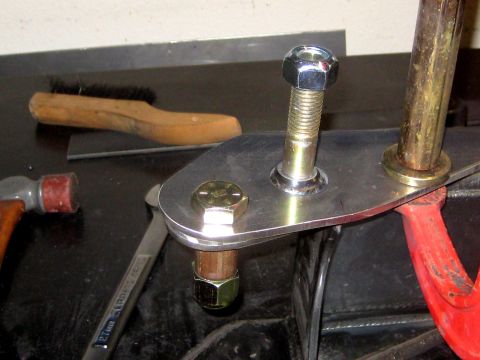 1996 Ford Bronco - Close-up view of a metal bracket with bolts and a red component, possibly part of a suspension system.