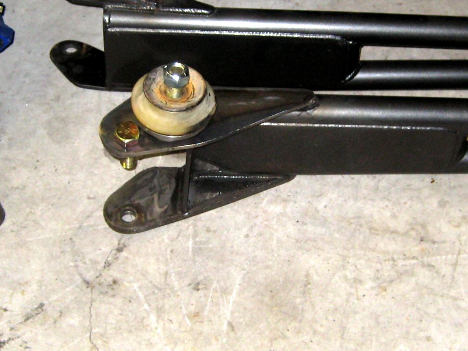 Close-up of a vehicle suspension component with a rubber bushing and bolts