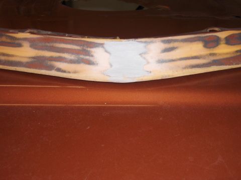 1980 Chevrolet Camaro - A car bumper shows areas of body filler and primer, indicating repair work.