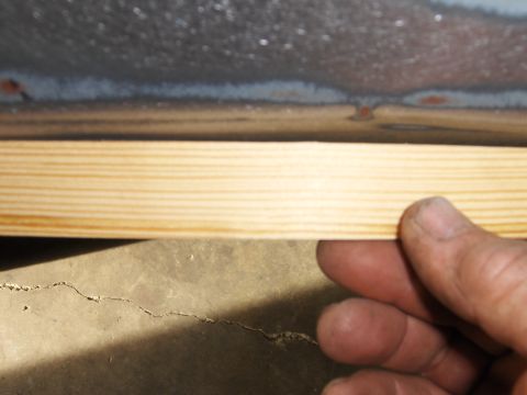 1980 Chevrolet Camaro - A hand holds a wooden strip against a metal surface, possibly for measurement or alignment.