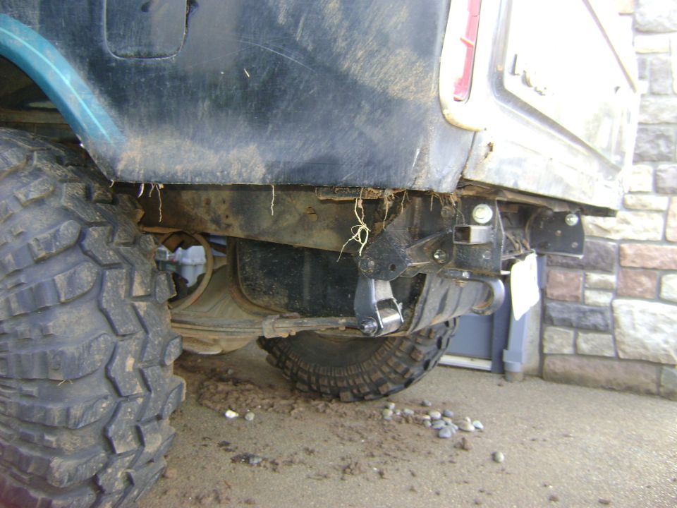 Rear tire and bumper assembly on a vehicle, with mud and debris visible
