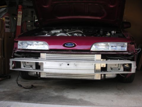 1992 Ford Crown Victoria - The front of a maroon 1992 Ford Crown Victoria is shown with its hood open, revealing the engine and intercooler system.