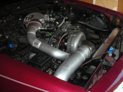1992 Ford Crown Victoria - Custom turbocharger and intercooler piping installed in the engine bay of a maroon vehicle.