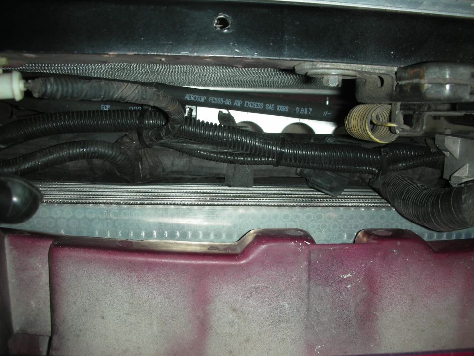 Engine bay wiring harness and radiator fins visible