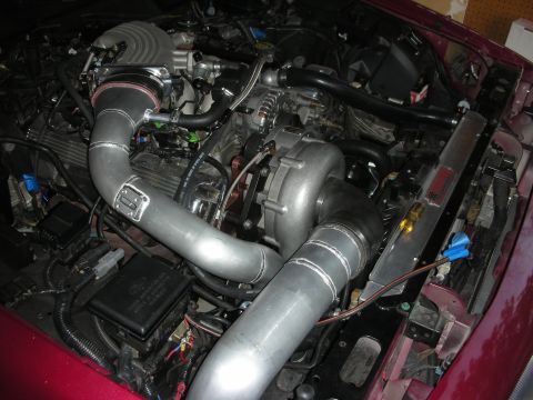 1992 Ford Crown Victoria - Custom turbocharger and intercooler piping installed in an engine bay, with maroon exterior paint visible.