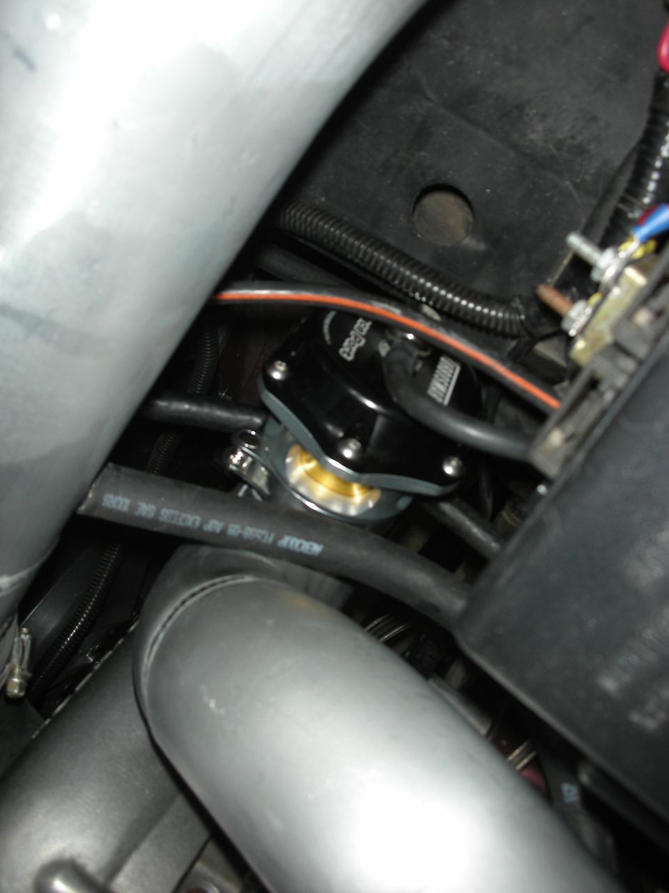 Black blow-off valve with gold diaphragm in engine bay