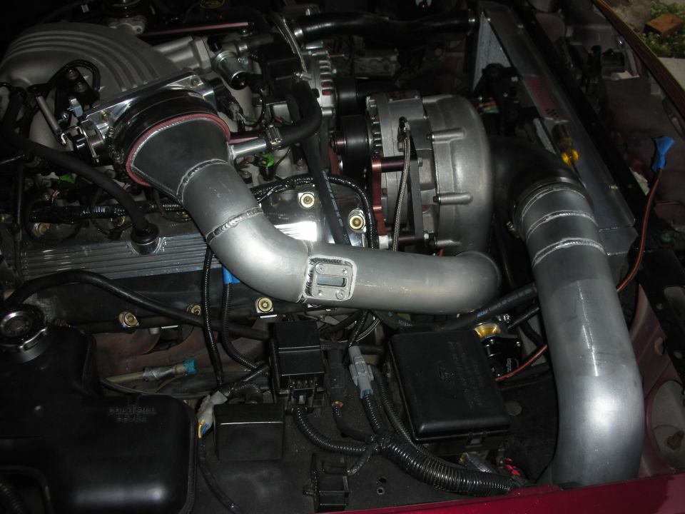 Engine bay with custom intercooler piping and supercharger