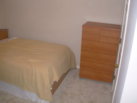 2004 Land Rover Land Rover - Interior of a bedroom showing a bed and a wooden dresser.