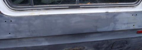 1979 Ford Bronco - The rear panel of a white and gray SUV, possibly from 1978, shows signs of bodywork and primer.