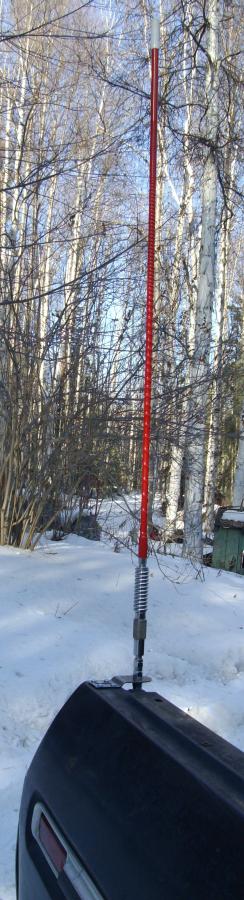 1978 Ford Bronco - CB antenna mounted on a vehicle fender in a snowy, wooded area.