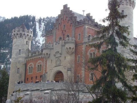 1948 Jeep Wrangler - A grand castle with multiple towers and ornate architecture stands before a snow-covered mountain range.