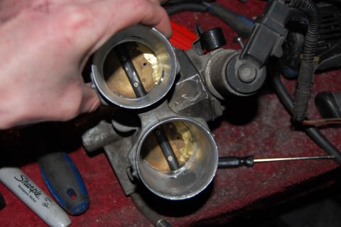 1994 Ford Bronco - Close-up view of a dual throttle body assembly, likely undergoing maintenance or modification.