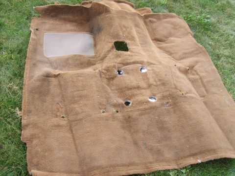 1989 Ford Bronco - This is a brown carpet piece with several cutouts, likely for a vehicle's interior components.
