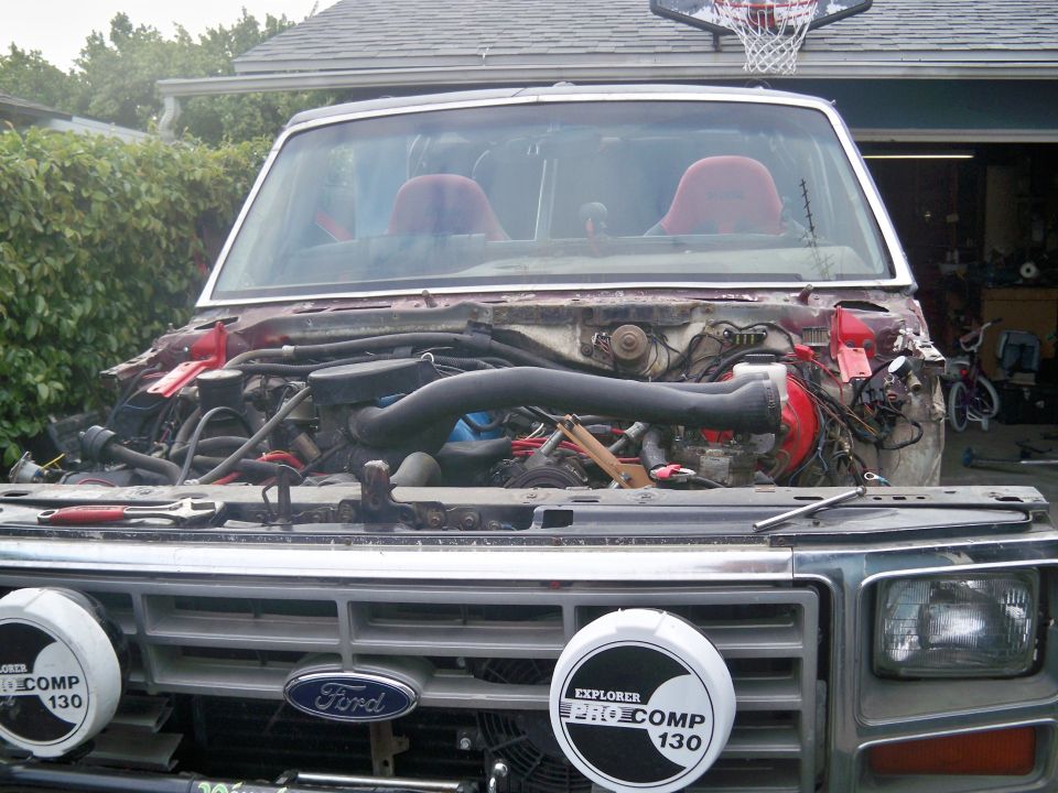 1985 Ford Bronco front view, hood removed, engine exposed. Red interior