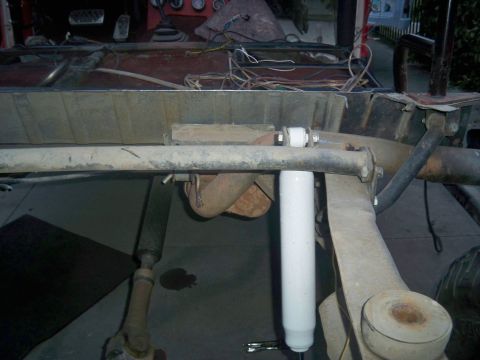 1985 Ford Bronco - Undercarriage view of a vehicle undergoing repairs, showing suspension and exhaust system components.