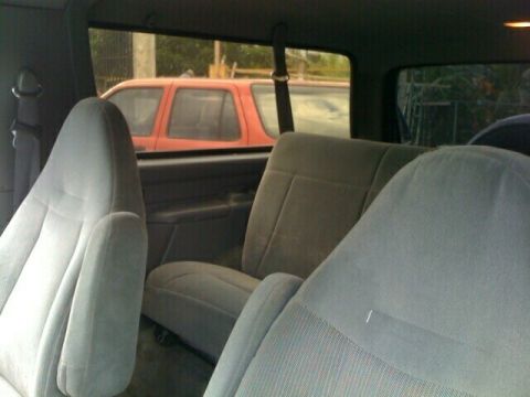1996 Ford Bronco - View from inside a vehicle, looking towards the rear seats and out the windows at another vehicle.