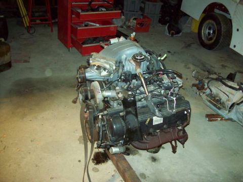 1993 Ford Crown Victoria - Engine and transmission assembly on a stand, with a red tool chest visible in the background.