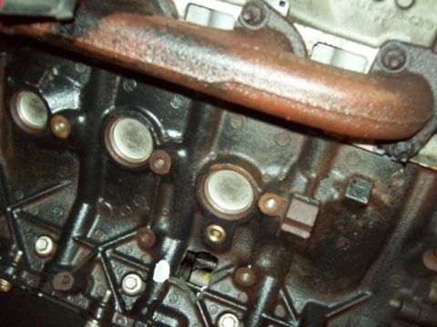 1993 Ford Crown Victoria - This is a close-up view of an engine block and a rusty exhaust manifold.