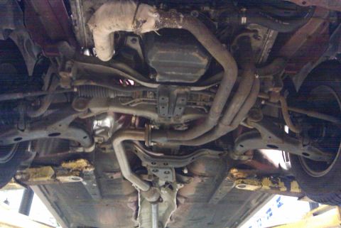 1998 Subaru Legacy - The underside of a vehicle is shown, revealing the exhaust system and suspension components.