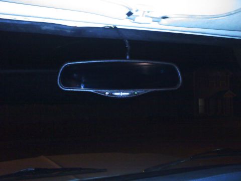 1977 Ford F-100 - The interior of a vehicle is visible, focusing on the rear-view mirror and dashboard area.