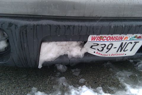 1998 Subaru Legacy - A rear bumper is partially obscured by snow, with a Wisconsin license plate visible.