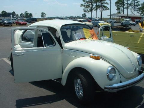 1972 Volkswagen Beetle - A white 1972 Volkswagen Beetle is displayed with its doors open, parked in an outdoor lot with other vehicles visible.
