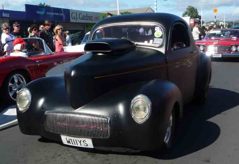 Black hot rod coupe with scoop on hood and flame details, front view