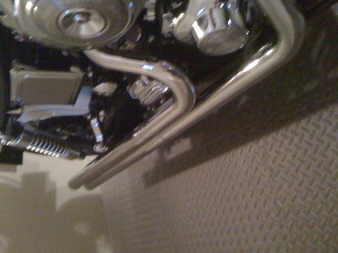 1984 Ford Bronco - Close-up view of a motorcycle's engine and chrome exhaust pipes.