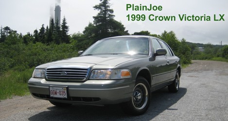 1999 Ford Crown Victoria - A 1999 Ford Crown Victoria LX is shown parked outdoors with a factory grille and headlights.