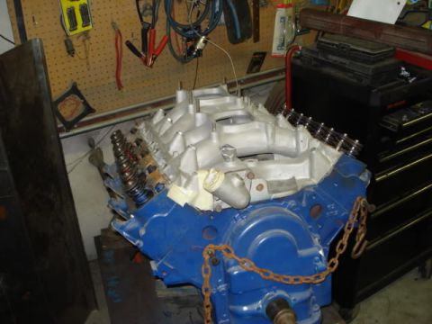 1978 Ford F-250 - A blue V8 engine block with a silver intake manifold is shown in a workshop setting.