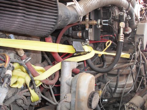 1991 Ford Bronco - Close-up of an engine compartment with various hoses and a yellow strap.