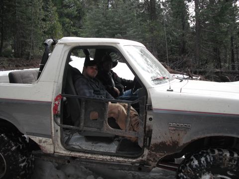 1991 Ford Bronco - The Bronco is equipped with off-road modifications, including a roll cage and large tires, for navigating snowy terrain.