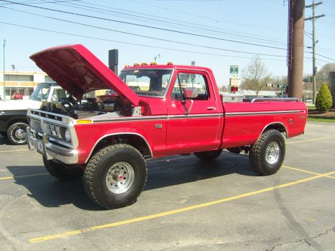 2007 Ford Mustang - A red pickup truck is parked in a lot with its hood up, revealing the engine compartment.