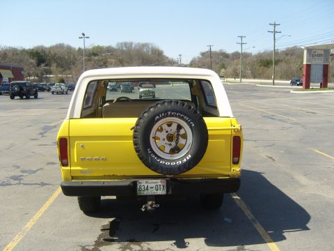 2007 Ford Mustang - Yellow Ford Bronco parked in a lot, showing its rear end and spare tire.