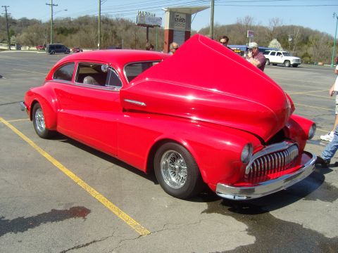 2007 Ford Mustang - A bright red custom coupe sits with its hood open, revealing the engine bay.