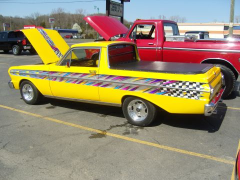 2007 Ford Mustang - A yellow pickup truck with custom racing stripes and checkered flag accents is parked next to a red truck.