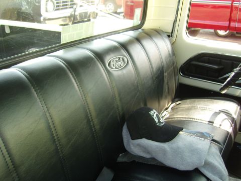 2007 Ford Mustang - Interior view of a vintage Ford truck, showing the bench seat and a glimpse of other vehicles outside.