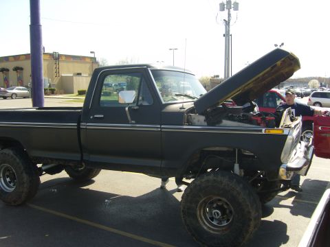 2007 Ford Mustang - This lifted black pickup truck, possibly a 1970s Ford, is shown with its hood open, revealing the engine compartment.