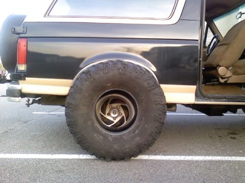 1990 Ford Bronco - The rear tire and body panel of a 1990 Ford Bronco are visible in this side view.