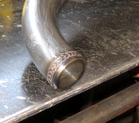 1996 Ford Bronco - A metal pipe section shows a clean weld at its capped end, resting on a workbench.